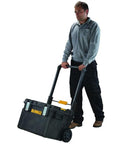 Man using Rugged ToughSystem Tool Box With Pull Back Lid For Maximum Storage Non Detachable Lid Wide Grip Handle on wheels