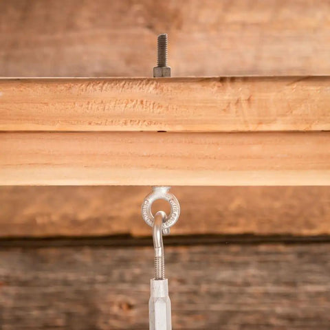 Three Eighth Inch Galvanized Eye Bolt Forged Steel Industrial Fastener Corrosion Resistant Outdoor Anchor secured to wood beam.