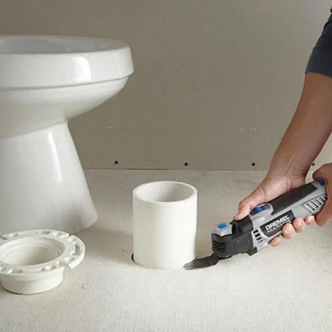 Top Notch 5 Amp Corded Oscillating Multi Tool Featuring Variable Speed And Low Vibration cutting a pipe opening near a toilet.