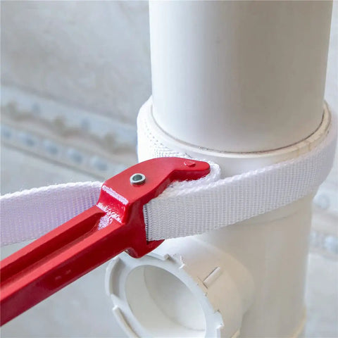 12 Inch Handle Strap Wrench With No Slip Adjustable Nylon Strap tightly gripping a white plastic pipe, showcasing red handle and white strap.