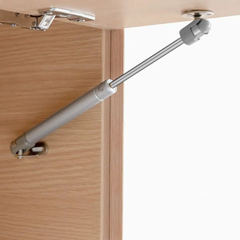 Slick Soft Close Gas Struts For Cabinets And Toy Boxes With Dead Sure Lifting Action Premium Safety Lift Supports, installed on wood cabinet.