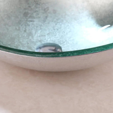 Close-up of Dope Sleek Oval Glass Vessel Sink and Waterfall Faucet Combo With Pop Up Drain showing glossy tempered glass finish.