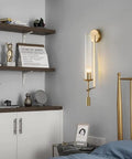 Smooth Gold Glass Wall Sconces With A Fresh Tubular Shape And Rock Solid Metal Build For Bedroom Or Hallway Decor Lighting delivering soft light next to bed.