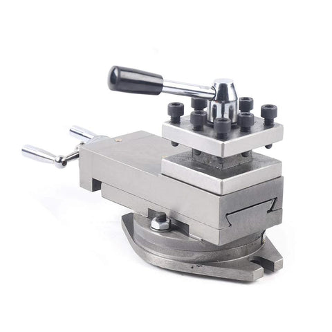 Lathe tool post assembly with quick-change holder, side view on circular rotary base; silver metal, black knobs