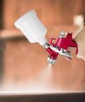 Heavy Duty Air Spray Gun With A Snazzy 600Cc Cup And Precise 1.5Mm Tip in hand showing detailed ergonomic design and spray action.