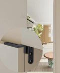 Close-up of stainless steel pivot hinge on a wooden door, showcasing its concealed design and silver-black finish for heavy load capacity.