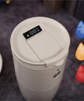 Top view of Compact Portable Coffee Maker With Built In Automatic Bean Grinder displaying temperature screen and lid.
