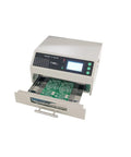Close-up of T962 V2.0 Intelligent Infrared IC Heater Soldering Furnace Reflow Oven with PCB inserted in tray, showing control panel.
