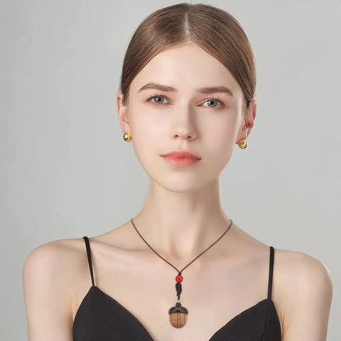 Woman wearing Five Pack Rainbow Wood Acorn Pendant Set With Openable Mini Cremation Urns For Ashes as a necklace, front view
