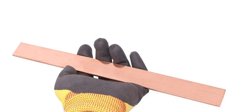 Gloved hand holding Copper Flat Bar C110 Grade One Eighth Inch Thick By One Inch Wide By Twelve Inch Long Solid Copper Plate Stock for DIYers