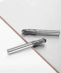 Side view of two 1/8 in ball-nose carbide end mills, 2-flute, on a white surface