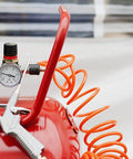 Red air compressor with hose, showcasing equipment for AirAid Air Tool Conditioner, Protective Coating, And Rust Inhibitor For Tools.