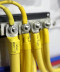 2104 PowerBar BusBar with four eighth inch terminal studs in use, connections with yellow cables visible, mounted on panel