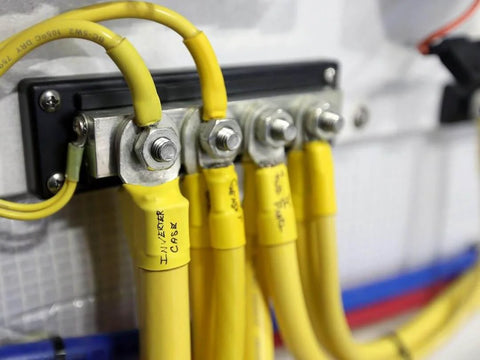 2104 PowerBar BusBar with four eighth inch terminal studs in use, connections with yellow cables visible, mounted on panel