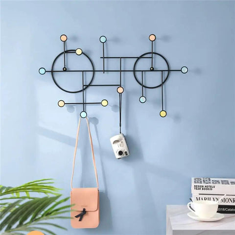 Heavy Duty Wall Mount Coat Hooks Built Tough With Premium Iron Metal hanging bags and camera on a blue wall.