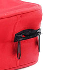 Close-up side view of red PAXLAMB first aid bag with dual zippers