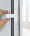 Fridge And Cabinet Safety Lock Set With Protective Plastic Covers, Quick Peel And Stick No Drill Install in use on fridge door.