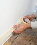 Person applying Masking Tape For Office And Home Projects With Strong Adhesive 0.70 Inch By 54.6 Yard on floor edge