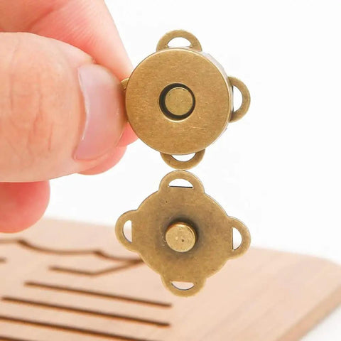 Rock Solid Magnetic Snap Buttons Sew On Clasp Kit Twelve Pack bronze alloy 15mm magnetic clasp held by fingers.