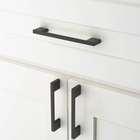 Matte black cabinet pulls installed on white cupboard drawers, featuring 10 Pack Matte Black Cabinet Pulls 5 Inch 128mm Hole Centers Kitchen Cabinet Handles For Cabinets Cupboard Drawers Hardware ZH0060 Durable, Easy To Install Long Lasting Finish.