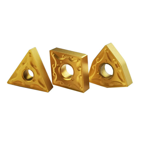 Three gold carbide lathe turning inserts (two triangular, one square) with center holes.