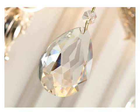 Close-up of a crystal pendant, showcasing its faceted surface, part of a wall sconce decor lighting fixture.