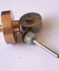 On/off valve part with copper disk and silver shaft; gray O-ring collar.