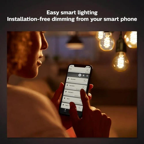 Person using smartphone to control Smart 60W ST19 Filament LED Bulb 2 Pack Soft Warm White 550LM E26 Indoor Lighting With Hue App
