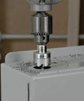 Front view of Klein Tools 31872 heavy-duty hole saw attached to a drill, cutting into a metal surface with metal shavings.