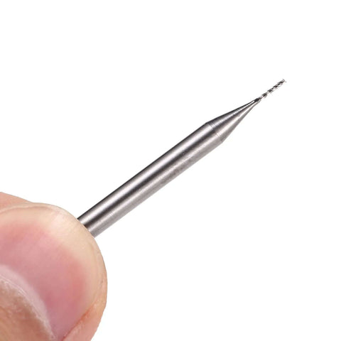 Close-up of a 0.6mm carbide end mill with a 1/8 inch shank for PCB engraving, held by fingers