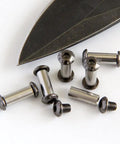 Knife Handle Hardware Kit ten pcs viewed with M4 hex head nuts and bolts near knife blade, 416 steel, DIY knifemaking.