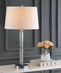 Vendome Modern Clear Glass 29 Inch Table Lamp with White Polyester Shade and Crystal Base on a Desk Next to Flowers and Books
