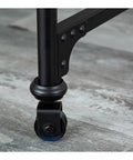 Slick Rolling Computer Desk Featuring Tight Vintage Industrial Lines And A Roomy Wood Surface Built For Home Office Setups With Heavy Duty Metal Base And Smooth Glide Casters. Close-up of metal caster wheel.