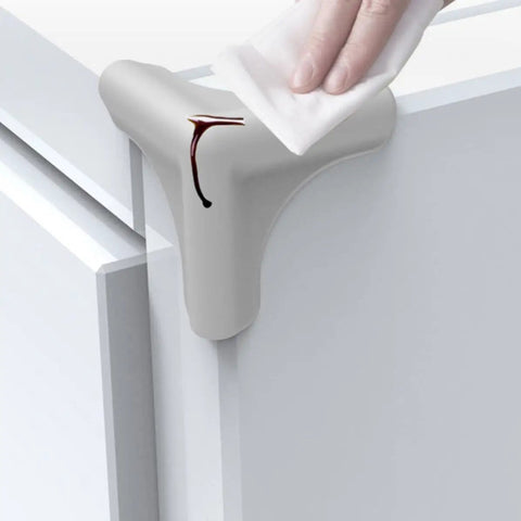 Silicone Corner Guards 8 Pack For Furniture Edges And Kitchen Table Corners, soft protector being cleaned with a cloth on a cabinet corner.