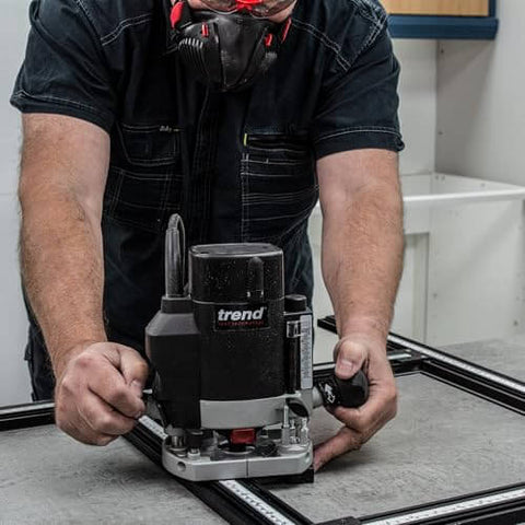 Worker using Adjustable Router Jig Frame and Guide System for Cutting Square and Rectangular Recesses, Slots, and Face Panel Molds