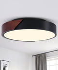 Super Stylish Modern Black Flush Mount Ceiling Light With Natural Wood Accents For That Cool Farmhouse Look Round Three Light Fixture Perfect For Bedroom Hallway Kitchen Laundry Room At Sixteen Point Five Inches with walnut wood accents in a room setting.