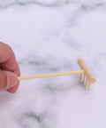 Hand holding a mini wooden rake from Dope 60 Piece Mini Zen Garden Rake Set For Desk Top Meditation And Sand Art