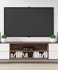 Modern entertainment center with TV, speakers, and books on a stand, showcasing home decor styling.