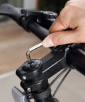 Adjusting bicycle handlebar with hex key tool for maintenance