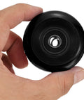Hand holding a black 54mm skateboard wheel with ABEC 9 bearings, part of the 54mm Skateboard Wheel Set With ABEC 9 Bearings Four Pack Cruiser.