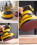 Close-up of a sanding disc attached to a random orbital sander, showing the use of 165 Piece 5 Inch Sanding Discs Set for Random Orbital Sander With Hook and Loop Backing, Assorted Grits 40 60 80 120 150 240 320 400 600 for Finishing and Polishing.
