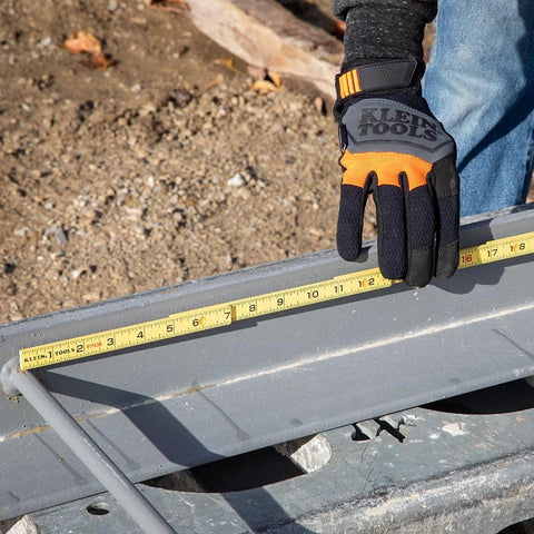 Person using Folding Ruler 6-Foot Fiberglass With Brick Scale On Reverse and Outside Reading One Sixteenth Inch Graduation for metalworking