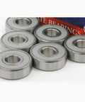 100-Pack 608-2RS Skate Ball Bearings - Gray Seals showing steel ball bearings in a row, ideal for skateboards and machinery.