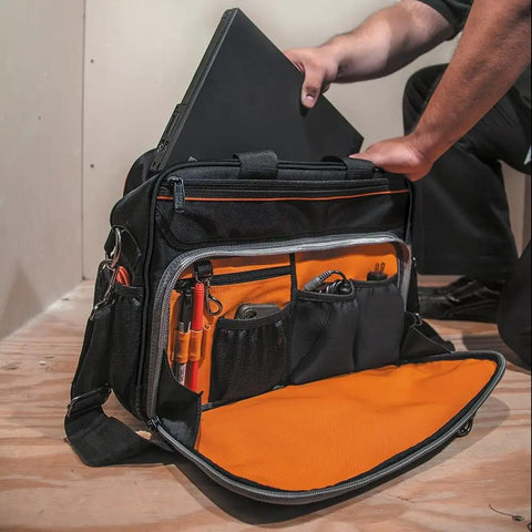 Tradesman Pro Tech Tool Bag With Laptop Pocket And 22 Pockets, black and orange bag with open tool compartments on floor