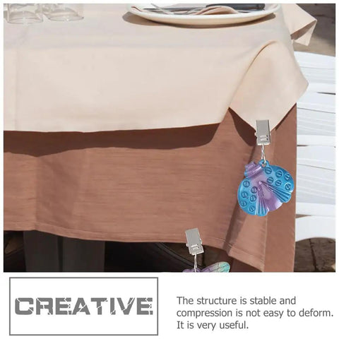 Alloy Tablecloth Clips Eight Pack 2.36 Inch Wide Non Slip Outdoor Tablecloth Holders securing beige tablecloth on patio.