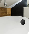 Matte Black Single Hole Bathtub Drain Overflow Plate With Solid Zinc Body And Matching Mounting Screws For A Sleek Look And Zero Drama Fast Install on a modern bathtub.