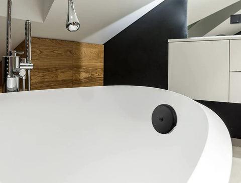 Matte Black Single Hole Bathtub Drain Overflow Plate With Solid Zinc Body And Matching Mounting Screws For A Sleek Look And Zero Drama Fast Install on a modern bathtub.