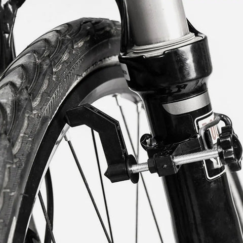 Spoke Tool With Spanner And Strap Compact Wheel Truing Stand For Road And Mountain Bikes Rim Alignment And Quick Repair Easy Tension Adjustments For Smoother Rides close-up on motorcycle fork with spoke tool attached for rim alignment.