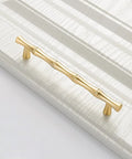 Bamboo Shape Solid Zinc Alloy Cabinet Knobs Set Of 6 In Golden Finish for drawers with smooth edges, shown installed on a panel.