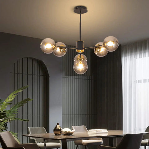 Six Light Glass Globe Sputnik Chandelier In Matte Black With Amber Shade in modern dining room setting.